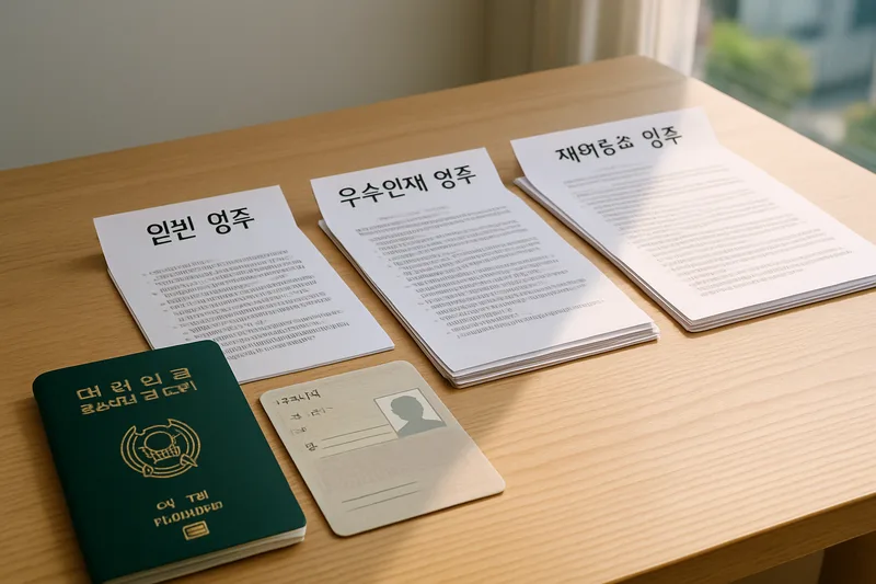 영주자격 유형별 서류를 분류해 책상 위에 정리한 모습, 여권과 체류 서류, F-5 영주권 종류