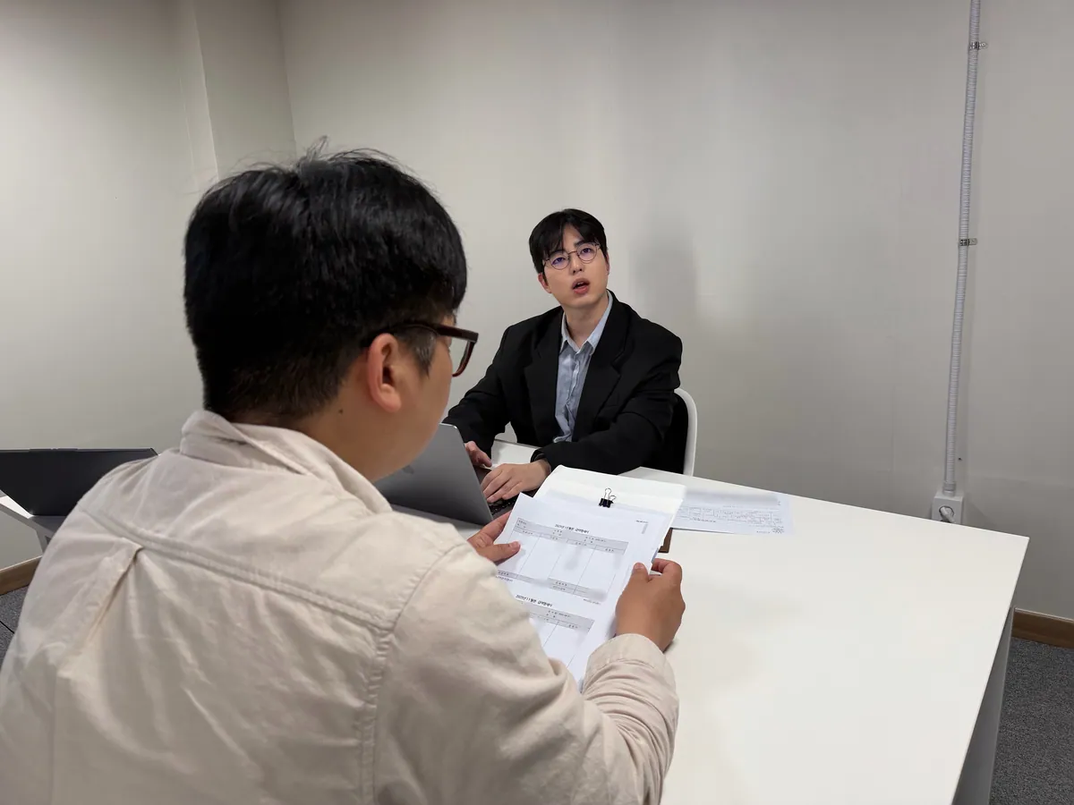 케이비자 상담실에서 담당자가 고객과 비자 서류를 상담하는 모습(고객 얼굴은 가렸어요)