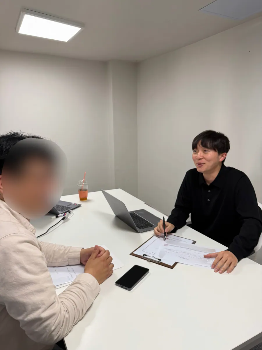 케이비자 상담실에서 담당자가 고객과 비자 서류를 상담하는 모습(고객 얼굴은 가렸어요)