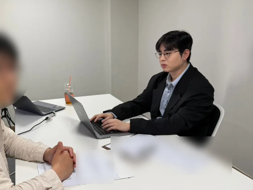 케이비자 상담실에서 담당자가 고객과 비자 서류를 상담하는 모습(고객 얼굴은 가렸어요)
