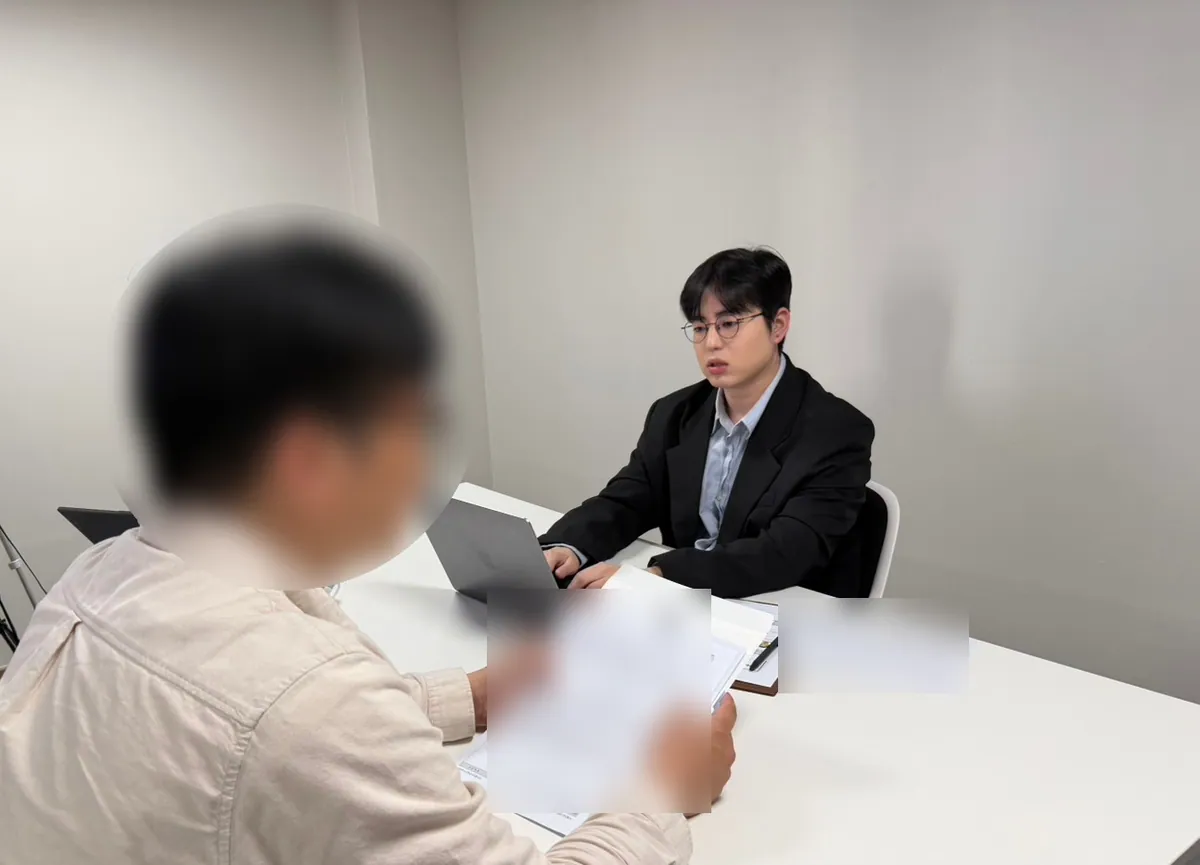 케이비자 상담실에서 담당자가 고객과 비자 서류를 상담하는 모습(고객 얼굴은 가렸어요)