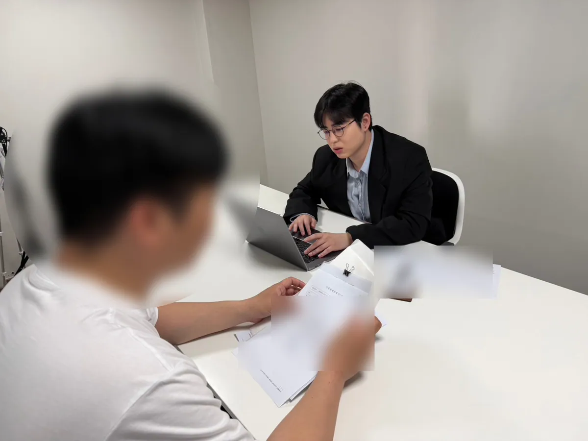 케이비자 상담실에서 담당자가 고객과 비자 서류를 상담하는 모습(고객 얼굴은 가렸어요)
