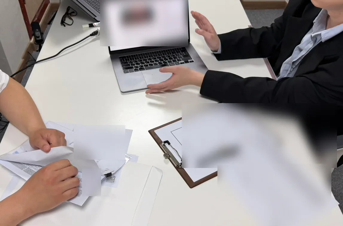 케이비자 상담실에서 담당자가 고객과 비자 서류를 상담하는 모습(고객 얼굴은 가렸어요)