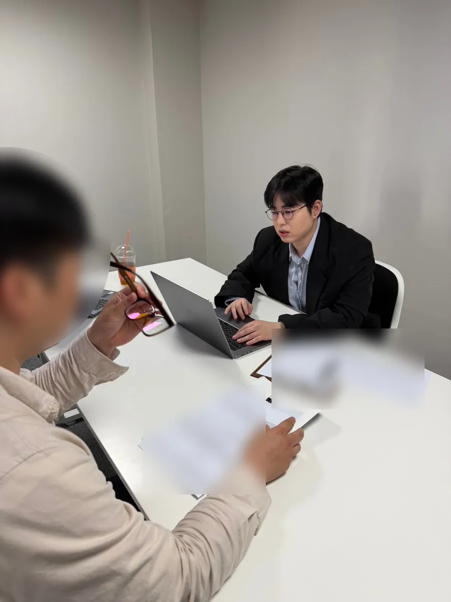 케이비자 상담실에서 담당자가 고객과 비자 서류를 상담하는 모습(고객 얼굴은 가렸어요)