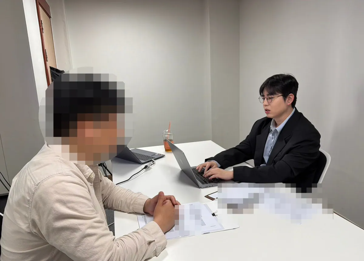 케이비자 상담실에서 담당자가 고객과 비자 서류를 상담하는 모습(고객 얼굴은 가렸어요)