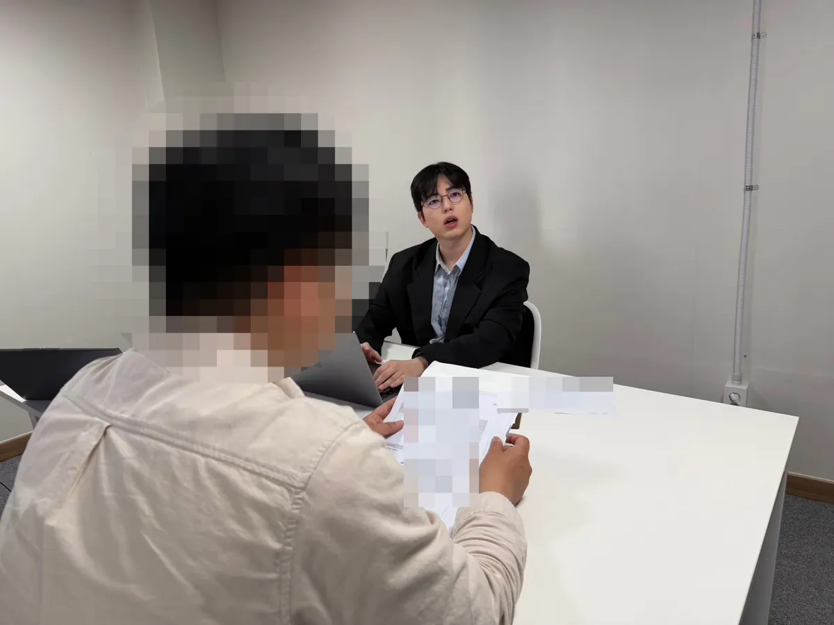 케이비자 상담실에서 담당자가 고객과 비자 서류를 상담하는 모습(고객 얼굴은 가렸어요)