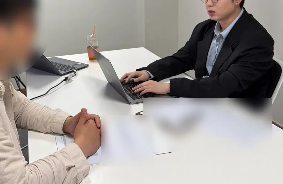 케이비자 상담실에서 담당자가 고객과 비자 서류를 상담하는 모습(고객 얼굴은 가렸어요)