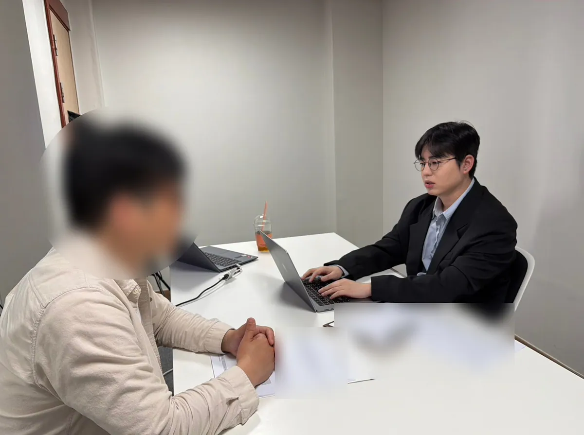 케이비자 상담실에서 담당자가 고객과 비자 서류를 상담하는 모습(고객 얼굴은 가렸어요)
