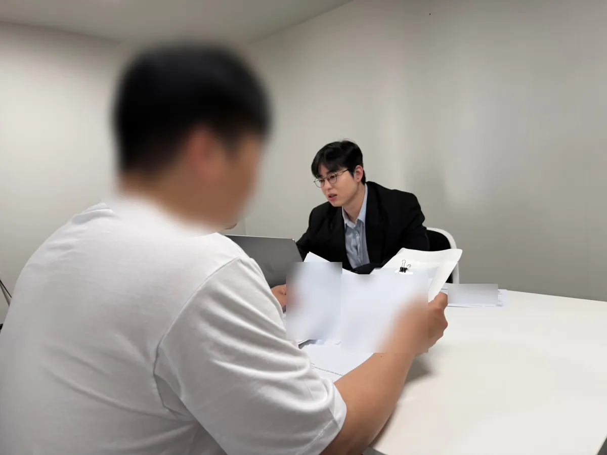 케이비자 상담실에서 담당자가 고객과 비자 서류를 상담하는 모습(고객 얼굴은 가렸어요)