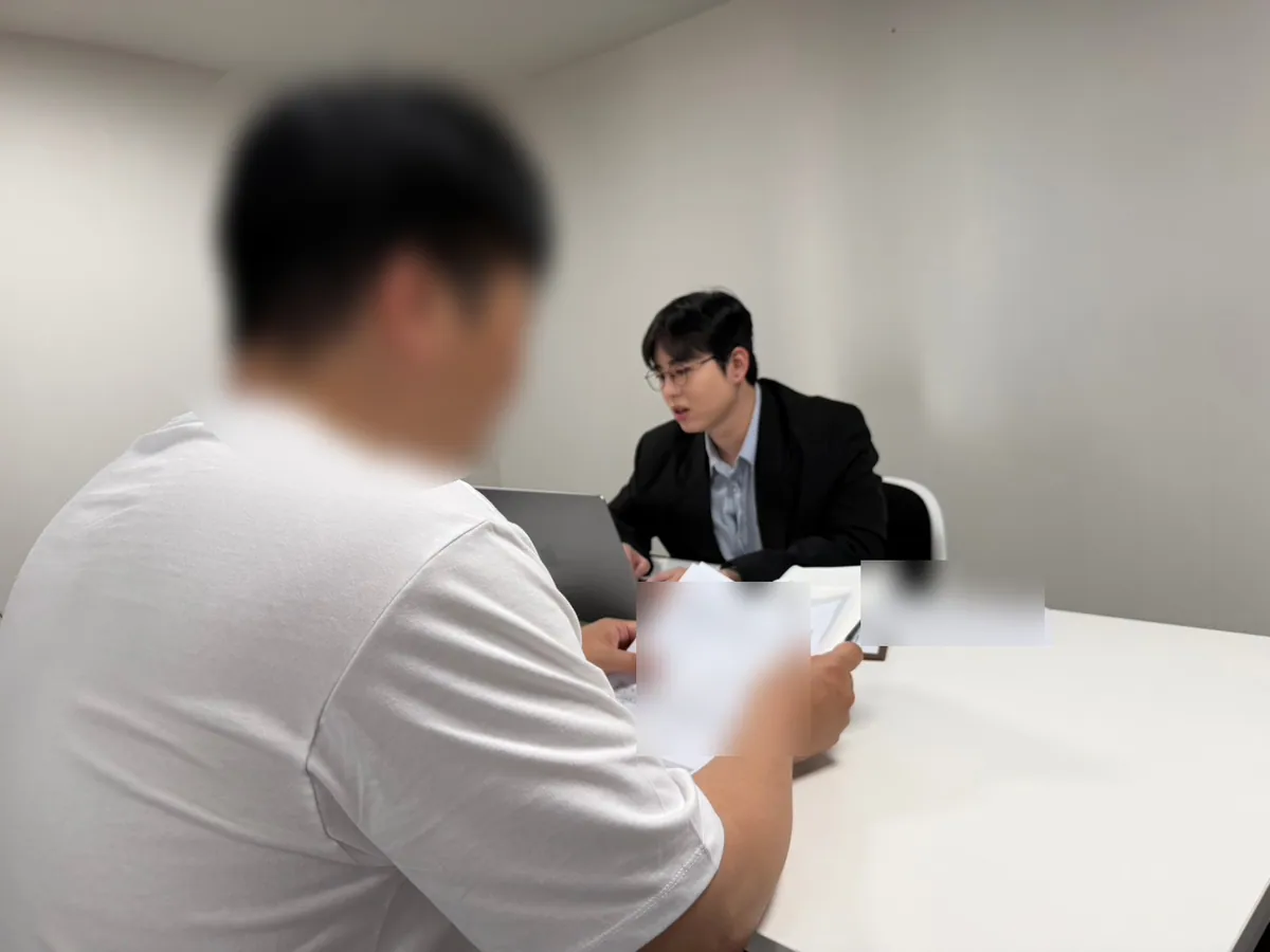 케이비자 상담실에서 담당자가 고객과 비자 서류를 상담하는 모습(고객 얼굴은 가렸어요)