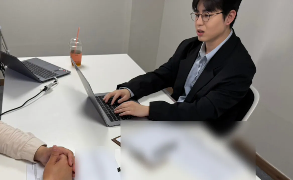 케이비자 상담실에서 담당자가 고객과 비자 서류를 상담하는 모습(고객 얼굴은 가렸어요)