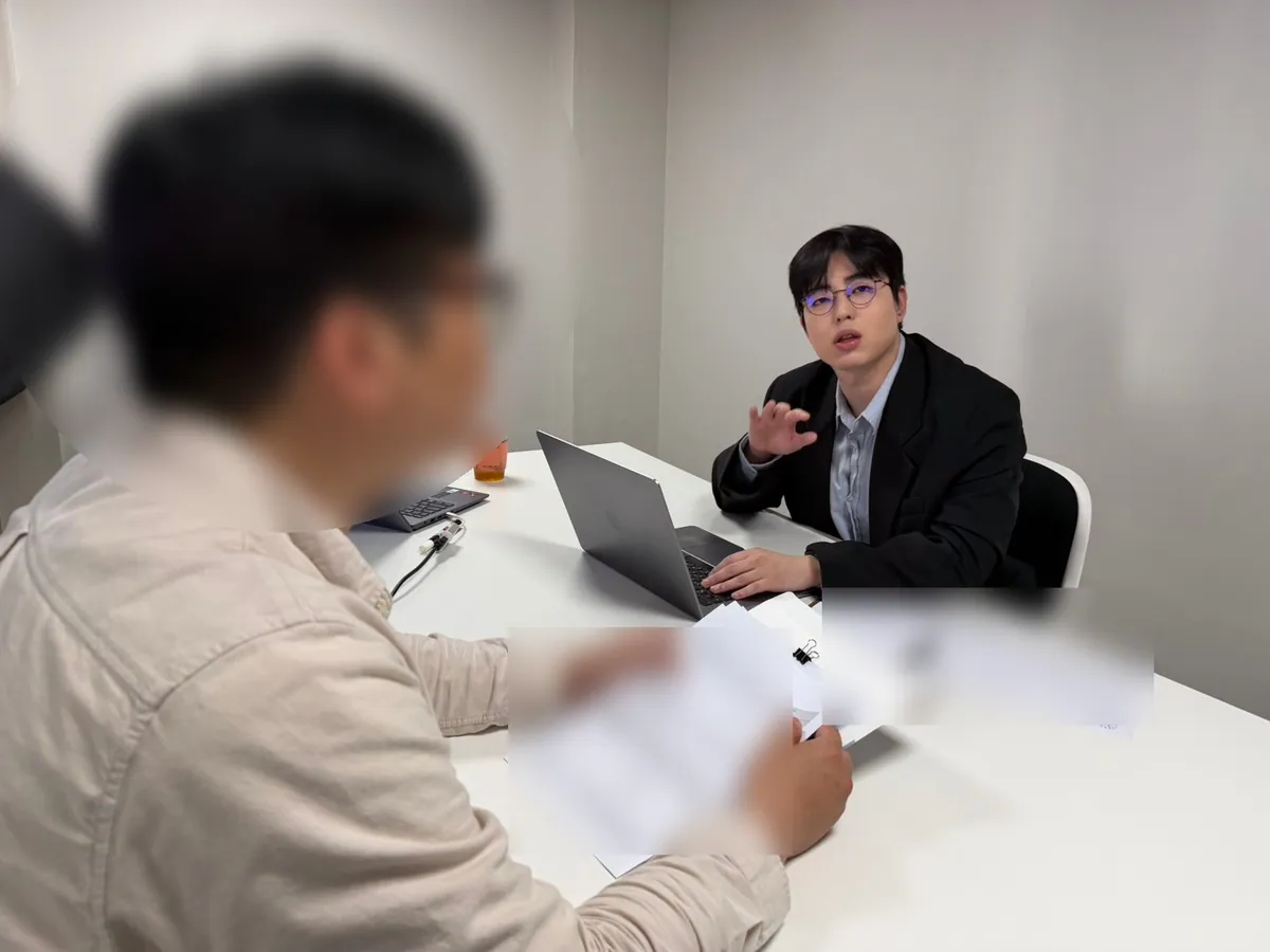 케이비자 상담실에서 담당자가 고객과 비자 서류를 상담하는 모습(고객 얼굴은 가렸어요)