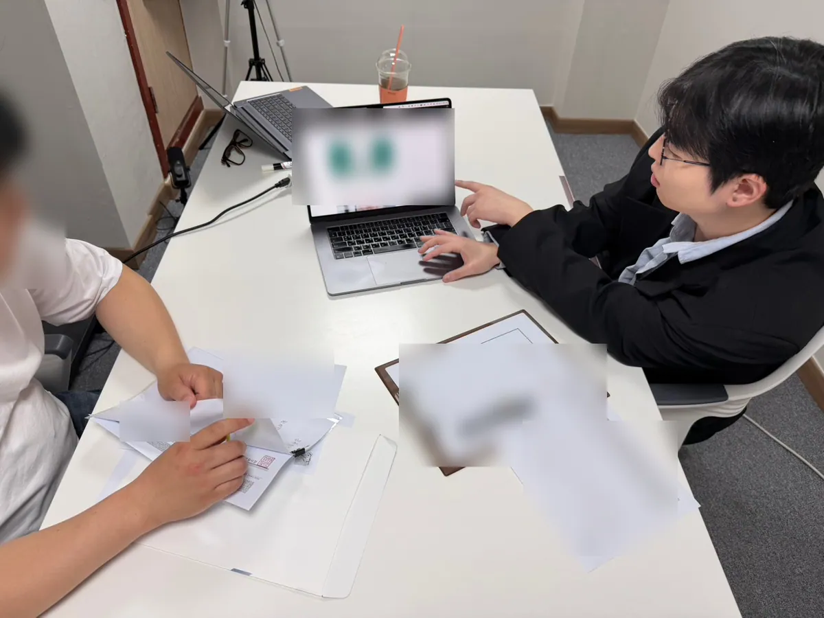 케이비자 상담실에서 담당자가 고객과 비자 서류를 상담하는 모습(고객 얼굴은 가렸어요)