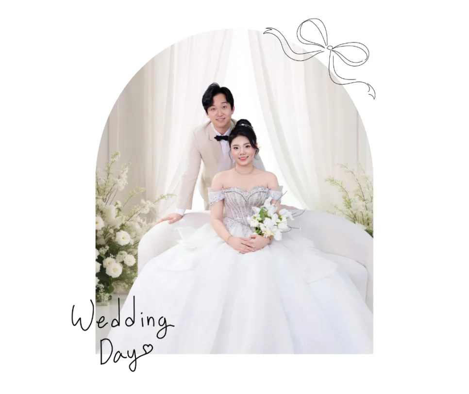 Wedding Day 글씨와 함께 흰 커튼 앞에서 웨딩드레스를 입은 아내와 베이지 정장을 입은 남편이 찍은 웨딩 사진